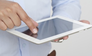 A computer ipad tablet with a hand touching a touchscreen